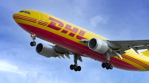 A DHL Express cargo plane flies overhead as the company expands its Philippine operations with a new €9-million Manila Gateway facility in Parañaque City aimed at boosting cargo handling capacity amid rising e-commerce and international trade demand.