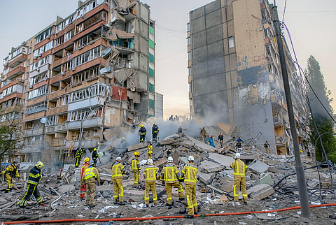 RESCUERS work at a residential building partially destroyed following Russian drone and missile strikes in Kyiv on 14 May 2026, amid the Russian invasion in Ukraine. 