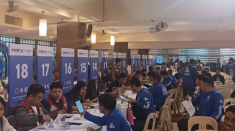 WORKERS from the Department of Social Welfare and Development distribute cash aid to motorcycle taxi riders and other TNVS drivers in Metro Manila.