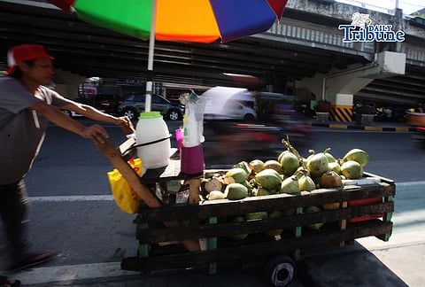 A vendor pushes his cart selling young coconuts, locally known as buko, along EDSA in Quezon City early in the morning as he earns money for his family’s daily expenses.