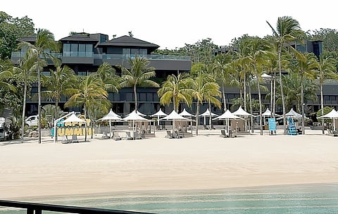 THE view approaching the resort by boat: dramatic black structures, thick greenery, and open sea welcoming guests to the island retreat.
