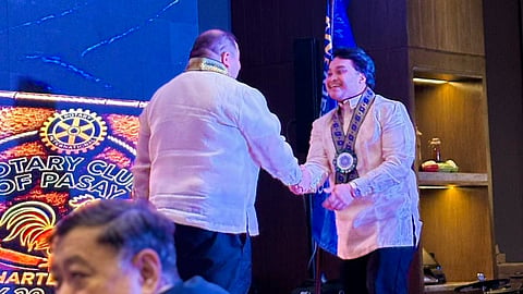 ROTARY Club of Pasay president Eric Pasion (left) shakes hands with incoming president Markley Villarin.