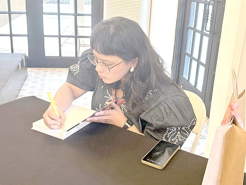 ATTY. Kathleen Tantuico signs her book for a fan during the launch of her masterpiece 'Archaeology and the Law: Legal Awareness and Advocacy in Philippine Archaeology' at the University of the Philippines Diliman.