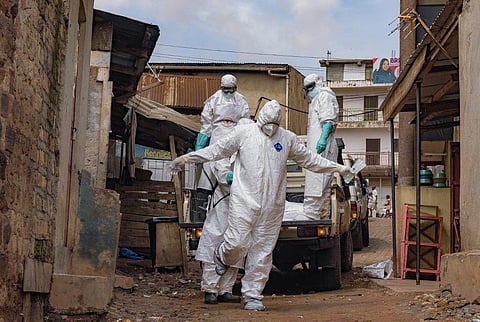 A UGANDA Red Cross Society worker in protective gear is sprayed with disinfectant during the evacuation of the body of a suspected Ebola victim in Kampala on 26 May 2026. 