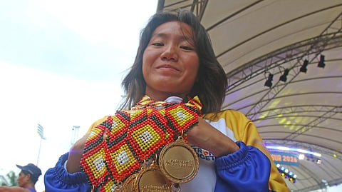 UST swimmer Patricia Mae Santor of the National Capital Region proudly displays her seven Palarong Pambansa gold medals on Friday in Agusan del Sur.