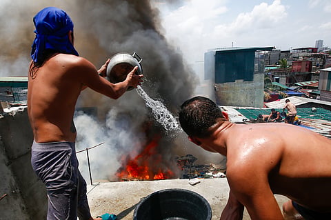 Firefighters and residents work together to control a raging third-alarm fire at the Baseco Compound in Port Area, Manila, on 30 May 2026. The incident comes just a week after a separate blaze gutted a nearby coastal community across the Pasig River.