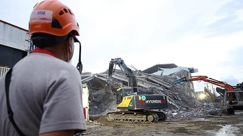 RESPONDERS continue search, rescue and retrieval operations at a collapsed building under construction in Angeles City, Pampanga, Tuesday. The death toll rose to 20 after emergency teams recovered three more victims from the rubble.   