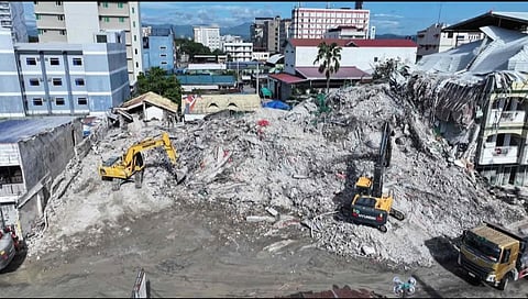 Systematic clearing and retrieval operations continue at the collapse site in Angeles City, with heavy machinery carefully removing debris to support ongoing search efforts.