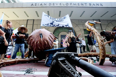 Civil society organizations, led by the NGO Forum on ADB and the Nuclear Free Bataan Movement, stage a creative protest to denounce the Asian Development Bank's role in deepening the global energy crisis. The groups protested the bank's continued fossil fuel financing, extractive investments, and false climate solutions outside the ADB office in Mandaluyong City on Wednesday, June 10, 2026. The demonstrators unveiled a giant "Kraken of destruction" to symbolize what they call the bank's system of energy capture.  | Photo by Analy Labor