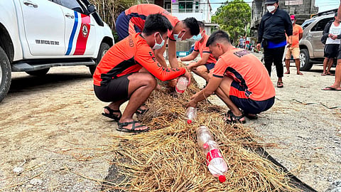 PERSONNEL from the Philippine Coast Guard fashioned makeshift absorbent pads to help contain and prevent the spread of an oil leak after a vessel ran aground near Barangay La Virgen in Ilocos Norte.