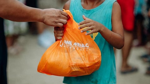 A RESIDENT of Barangay Mudan in Glan, Sarangani receives a food bag from OMF.