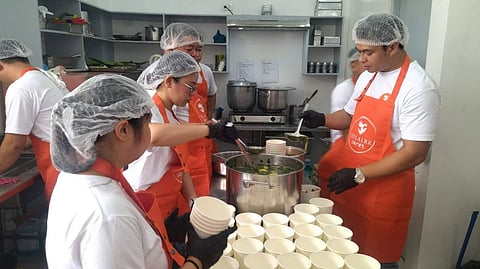 VOLUNTEERS from Solaire Cares prepare hot meals for children of Barangay San Dionisio, Paranaque City. 
