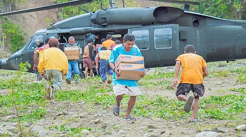 RESIDENTS of Barangay Laguimit in Glan, Sarangani Province carry family food packs delivered as humanitarian assistance over the weekend.