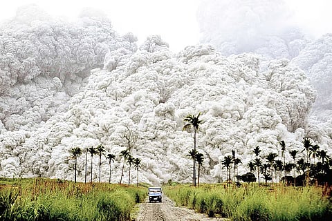 Mount Pinatubo released pyroclastic materials while a blue vehicle outran a deadly, cauliflower-like ash cloud within the danger zone in Botolan, Zambales, early in the morning of June 15, 1991. The photo, captured by a Filipino photographer, won the 1992 World Press Photo Award in Amsterdam under the Nature category and was later included in TIME Magazine’s list of the “Greatest Images of the 20th Century” as well as National Geographic’s “100 Best Pictures of the 20th Century.” (Photo courtesy of Alberto Garcia). 
