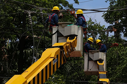 Workers from Meralco repair downed power lines in Malabon City on 22 June 2026, following a severe downpour the previous evening. Sudden strong winds and heavy rains caused three electrical posts to topple, cutting off electricity, phone lines, and internet services for local residents.
