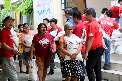 RESIDENTS of Barangay Doña Imelda in Quezon City line up to receive rice packs during a local distribution caravan on Monday. Spearheaded by First Lady Liza Araneta-Marcos, the metropolis-wide relief initiative aims to provide immediate food assistance to vulnerable families, driven by the advocacy that every Filipino family deserves food on the table. 
