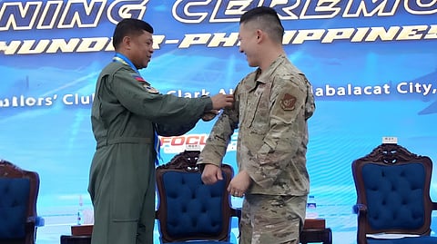 BRIG. Gen. Alfredo Antonio Jr. (left) affixes the official Exercise Cope Thunder 26-2 patch onto Lt. Col. Samuel Pang during the opening ceremony of the joint military training at Clark Air Base in Mabalacat City, Pampanga.