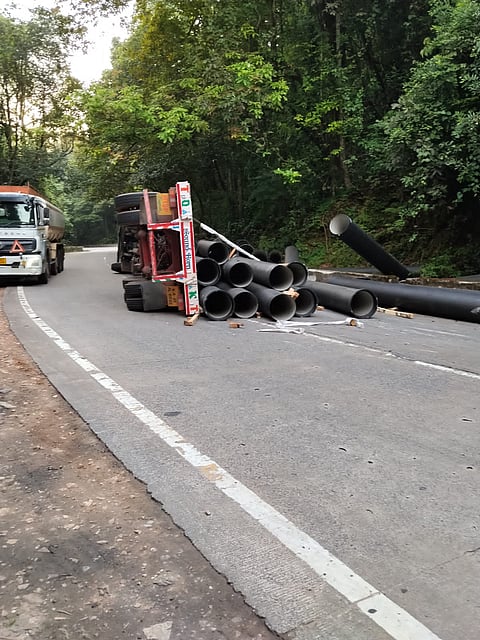 ಹೆದ್ದಾರಿಯಲ್ಲಿ ಲಾರಿ ಮಗುಚಿ ಬಿದ್ದಿರುವುದು.