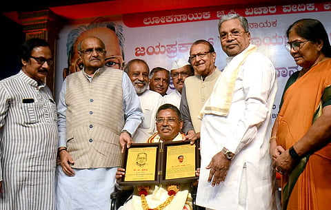 Former Chief Minister Siddaramaiah honored former MP V.S. Ugrappa with the J.P. Award. K.C. Tyagi, V.R. Sudarshan, B.L. Shankar, and others were present.