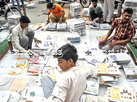 263805-distributors-sort-through-newspapers-before-selling-them-during-early-