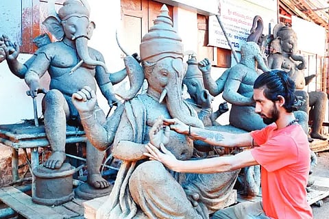Artist giving Finishing touch for Ganesh Idol.