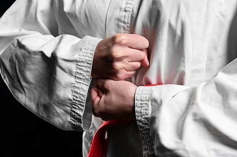 karate-athlete-with-red-belt-posing-closeup_23-2148990932