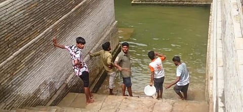 Youths clean an ancient well