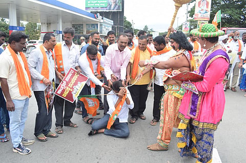 BJP protests demanding closure of road potholes Mandya
