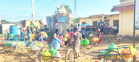 Villagers climb on top of tank for water