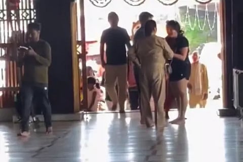 Woman in shorts argues with priest