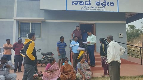  ಬೆಳಗೊಳ ನಾಡ ಕಚೇರಿ ಮುಂಭಾಗ ಉಪ ತಹಸೀಲ್ದಾರ್ ವರುಣ್‌ಗೆ ಹುಲಿಕೆರೆ ನಿವಾಸಿ ಜಗದೀಶ್ ಹಾಗೂ ಕುಟುಂಬದವರು ಮಾಹಿತಿ ನೀಡುತ್ತಿರುವುದು.