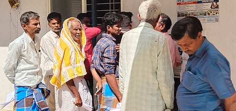  ಹನೂರಿನ ತಹಸೀಲ್ದಾರ್ ಕಚೇರಿಯ ಆವರಣದಲ್ಲಿನ ಅಭಿಲೇಖಾಲಯದಲ್ಲಿ ಅಗತ್ಯ ದಾಖಲೆ ಪಡೆಯಲು ಜನರು ಬಿಸಿಲಿನಲ್ಲಿ ಕಾದು ನಿಂತಿರುವುದು.   