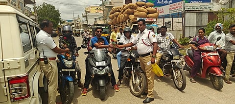 ಕೊಪ್ಪಳದಲ್ಲಿ ಶನಿವಾರ ಹೆಲ್ಮೆಟ್​ ಧರಿಸುವಂತೆ ಸವಾರರಿಗೆ ಹೂ ನೀಡಿ ಜಾಗೃತಿ ಮೂಡಿಸಿದ ಟ್ರಾಫಿಕ್​ ಪಿಎಸ್​ಐ ವೆಂಕಟೇಶ ಹಾಗೂ ಸಿಬ್ಬಂದಿ.