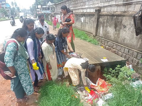 ಉಡುಪಿಯ ಬನ್ನಂಜೆ ಕೆಎಸ್​ಆರ್​ಟಿಸಿ ಬಸ್​ ನಿಲ್ದಾಣ ಸಮೀಪದ ಚರಂಡಿಯಲ್ಲಿ ಎಸೆದಿರುವ ಕಸದಲ್ಲಿ ಮನೆಯ ವಿಳಾಸ ಸಿಗಬಹುದೇ ಎಂದು ಪರಿಶೀಲಿಸುತ್ತಿರುವ ಕಮ್ಯುನಿಟಿ ಮೊಬೈಲೈಸರ್​ ತಂಡ.