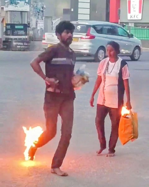 ಉಡುಪಿಯ ಕಲ್ಸಂಕ ವೃತ್ತದಲ್ಲಿ ಕಾಲಿಗೆ ಪೆಟ್ರೋಲ್​ ಸುರಿದುಕೊಂಡು ಬೆಂಕಿ ಹಚ್ಚಿಕೊಂಡು ಹುಚ್ಚಾಟ ನಡೆಸಿದ ವ್ಯಕ್ತಿ.