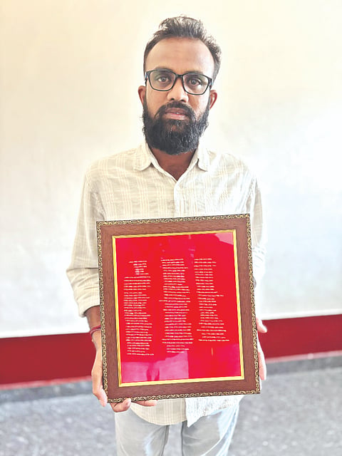  ಅಕ್ಕಿ ಕಾಳಿನಲ್ಲಿ ಬರೆದಿರುವ ಸ್ತೋತ್ರದೊಂದಿಗೆ ಮೈಕ್ರೋ ಪರಮೇಶ್.