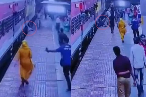ರೈಲು ಹಾಗೂ ಫ್ಲಾಟ್​ಪಾರ್ಮ್​ ನಡುವೆ ಸಿಲುಕಿಕೊಂಡಿರುವ ಯುವಕನನ್ನು ರಕ್ಷಿಸುತ್ತಿರುವ ಆರ್​.ಪಿ.ಎಫ್​ ಸಿಬ್ಬಂದಿ