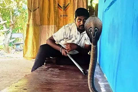 ನಾಗರ ಹಾವೊಂದನ್ನು ಹಿಡಿದಿರುವ ಉರಗ ತ ಅವಿನಾಶ ಬೆಳಗಾಲ.