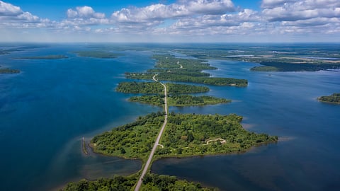 Aerial photo of Long Sault Parkway scenic route crossing Thousand Islands archipelago in the Saint Lawrence River near Cornwall, South Stormont, Ontario, Canada. Photo taken by drone in June 2022.