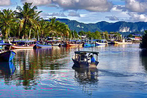 A local fisherman goes out on a boat from boats park to the sea for fishing. 