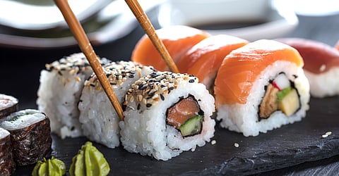 Close-up of sushi with chopsticks.