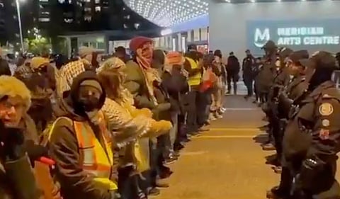 Masked pro-Palestinian protesters face off against row of police officers while chanting: “If we don’t get no justice, then you don’t get no peace!”
