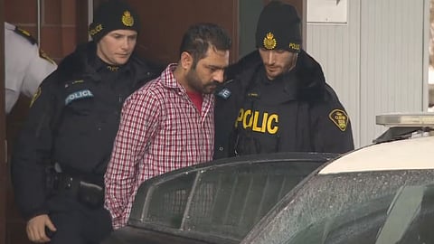 Yasir Baig being led out of his 2018 bail hearing in Brampton, Ontario