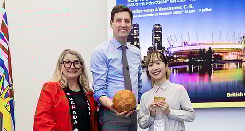 Premier David Eby poses with a wood-leather soccer ball in Japan