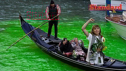 Greta Thunberg in a Gondola over the dyed green water