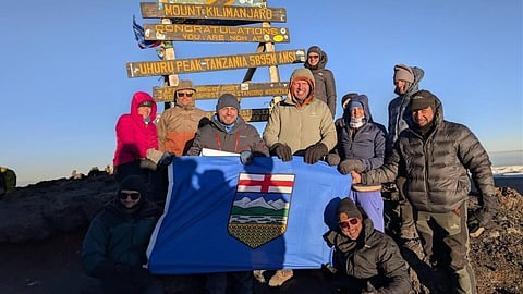 Demetrios Nicolaides plants the Alberta flag on Mt. Kilimanjaro