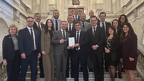 Member of the UCP caucus and MP Garnett Genuis taking a photo with Alberta's Bill 18. 