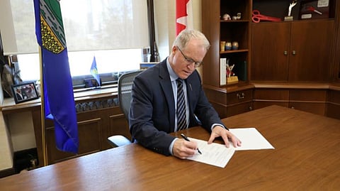 Environment and Protected Areas Minister Grant Hunter signing the Canada-Alberta Cooperation Agreement on Environmental and Impact Assessment