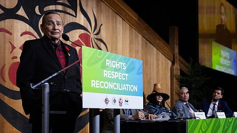Grand Chief Stewart Phillip of the Union of BC Indian Chiefs addresses the annual BC cabinet and First Nations leadership gathering in Vancouver, Nov. 4, 2025. On the stage from right: Premier David Eby, Assembly of First Nations regional chief Terry Teegee, and Cowichan hereditary Chief Shana Thomas of the First Nations Summit.