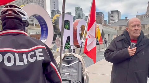A man in Toronto continues to sing the Canadian anthem after police turned off his loudspeaker